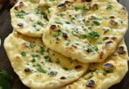 Cheese naan doré, coupé pour révéler un cœur fondant de fromage, servi avec du curry.